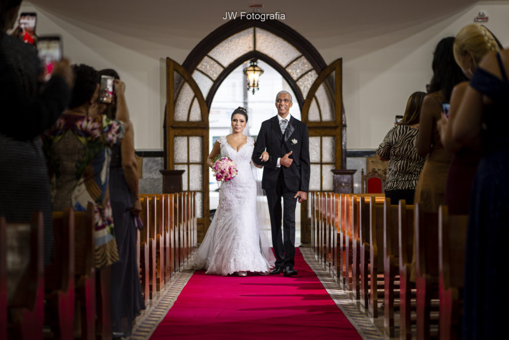 dicas para economizar no casamento - noiva no tapete vermelho de braços dados.