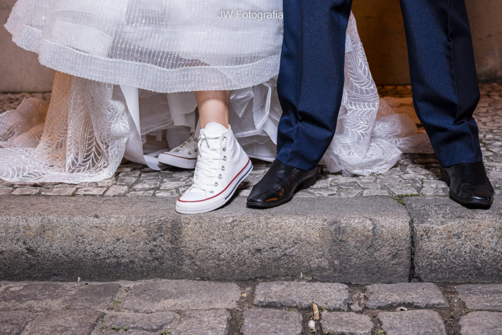 inspirações para festa de casamento - casal moderno mostrando seus sapatos. sendo o da noiva um All Star branco cano longo.