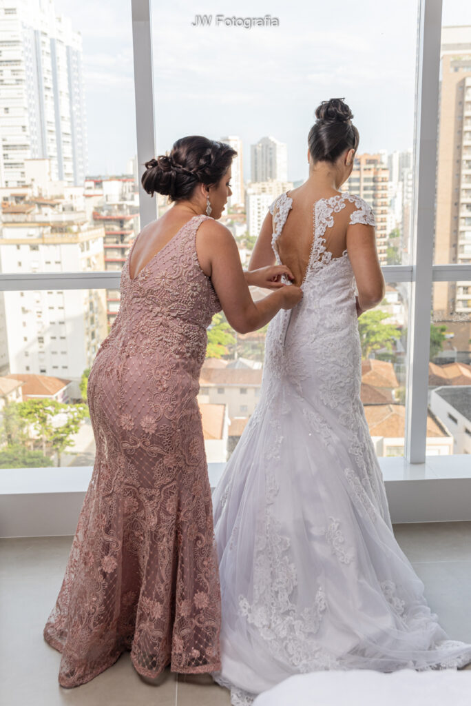 dicas de vestido de noiva ideal - mãe ajudando a filha a vestir seu lindo vestido.